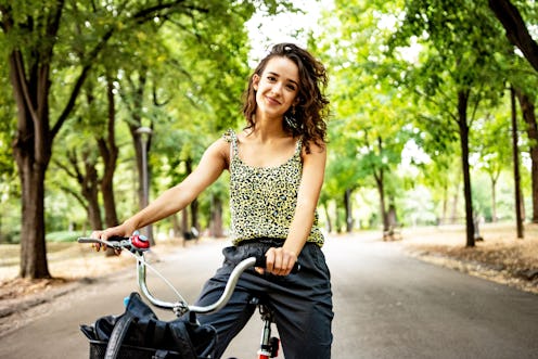 Beautiful young woman enjoying riding bike at the park