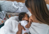 A woman breastfeeding her baby daughter in an article about cramping while breastfeeding