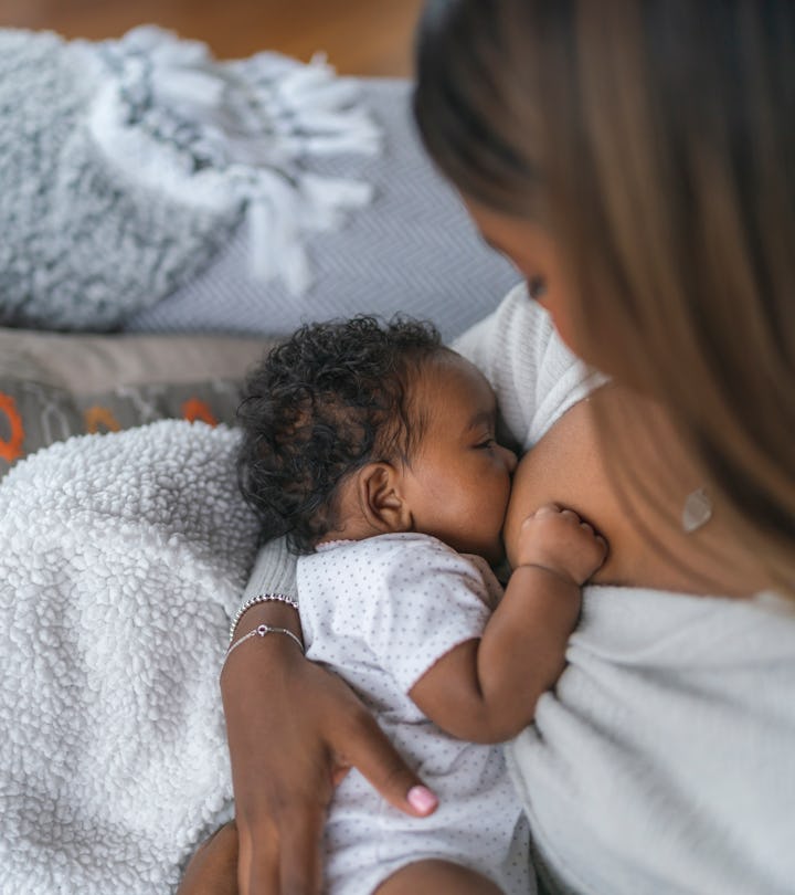 A woman breastfeeding her baby daughter in an article about cramping while breastfeeding