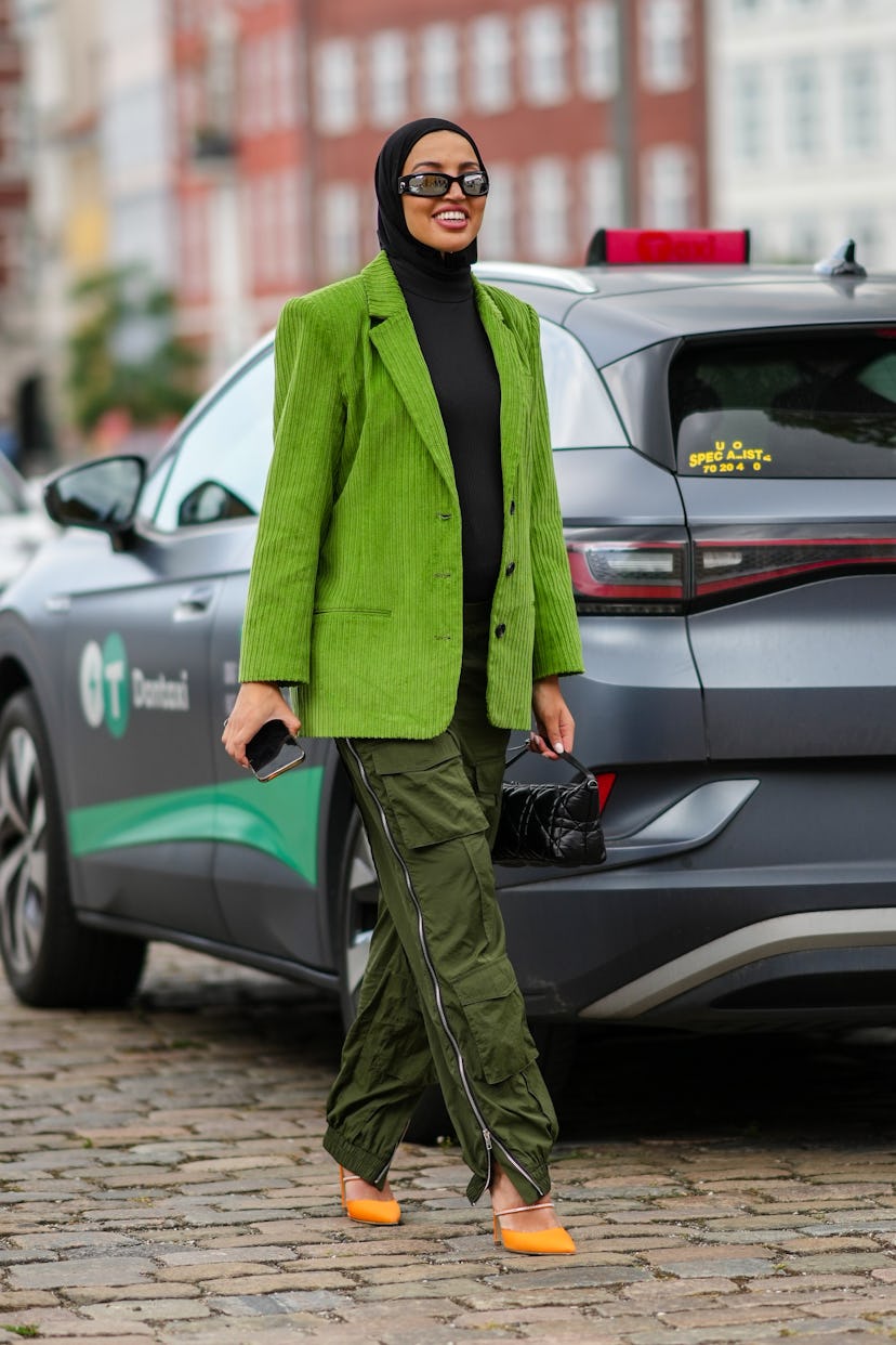 COPENHAGEN, DENMARK - AUGUST 09: A guest wears black sunglasses from Marine Serre, black scarf, a bl...