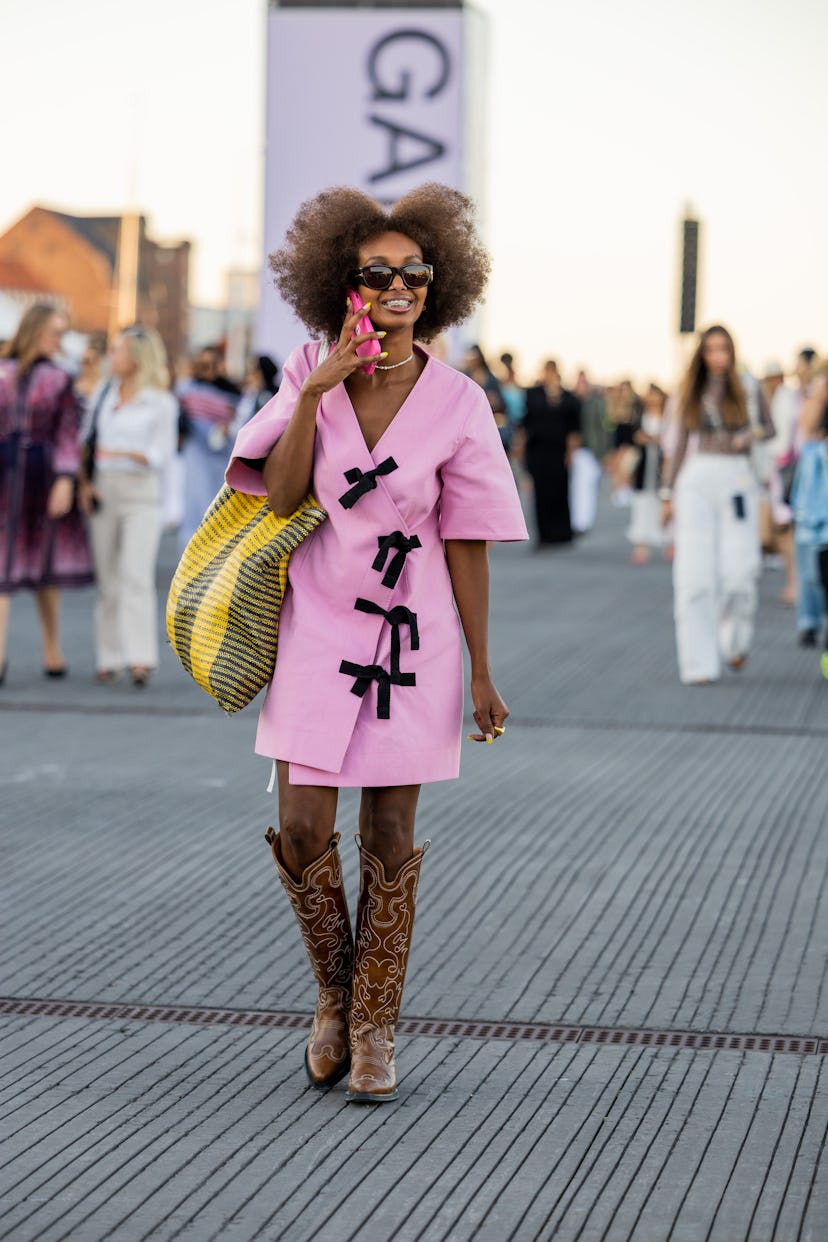 COPENHAGEN, DENMARK - AUGUST 11: Mona M. Ali is seen wearing pink dress, cowboy boots outside Ganni ...