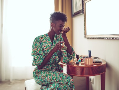 Young woman at home smelling her signature fall scent and signature fall fragrance based on her zodi...