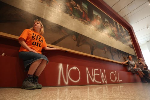 Protesters from Just Stop Oil climate protest group glue their hands to the frame of a copy of Leona...