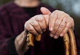 What's a toxic grandparent? Close-up of senior woman's hands holding her walking sticks.