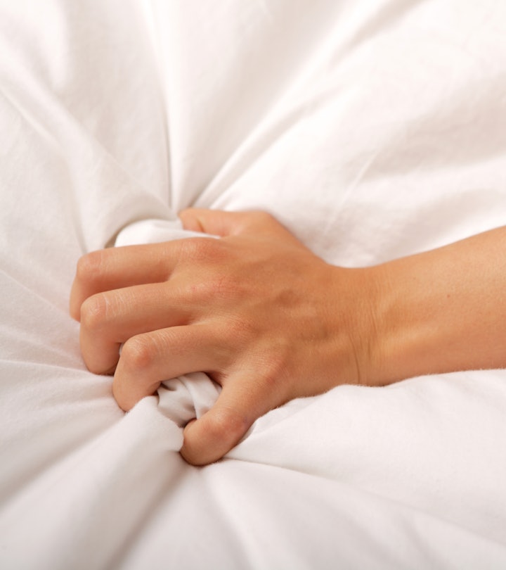 Hand grabbing onto a white sheet in an article about does masturbation reduce sperm count?