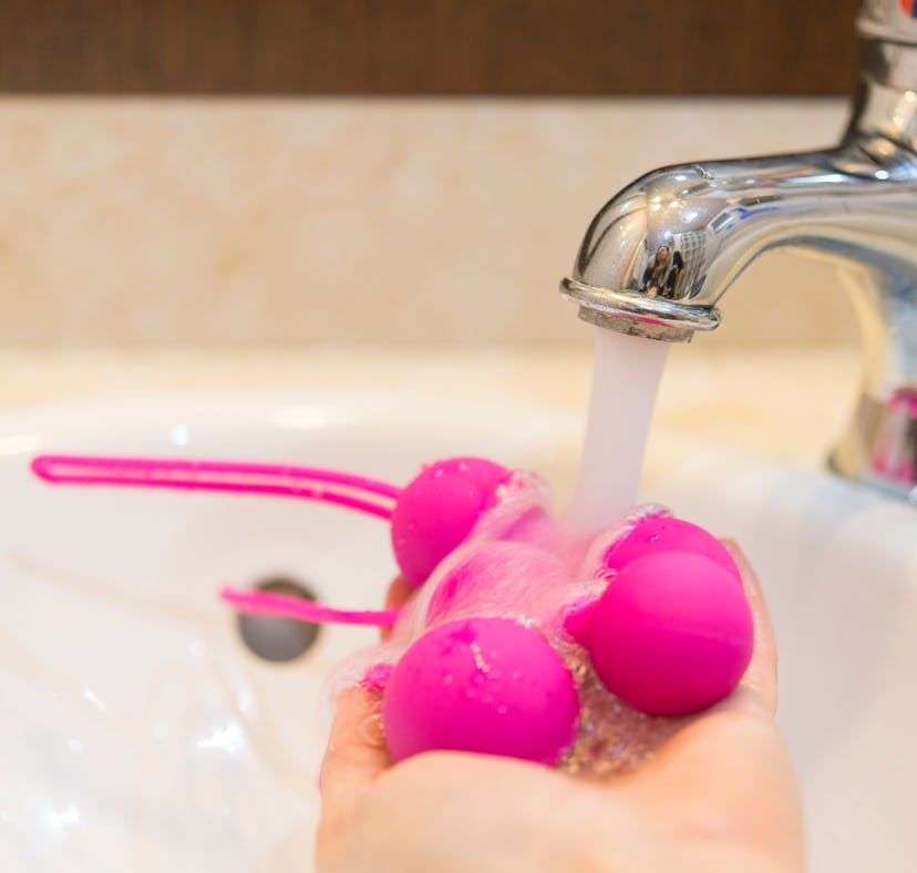 Woman cleaning her waterproof sex toy after using it in the shower
