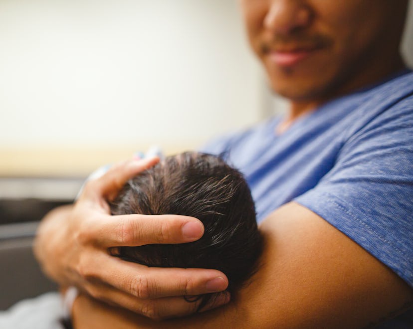 A father holding his newborn baby after attending the labor