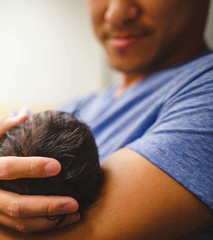 A father holding his newborn baby after attending the labor
