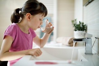 Young girl rinsing mouth in the bathroom