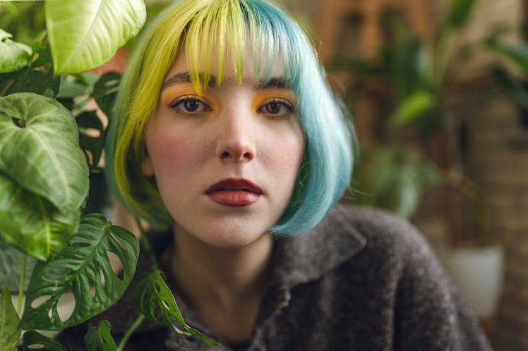 Young woman with colorful hair thinking about astrology elements