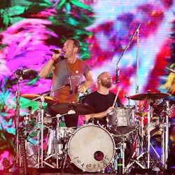 Chris Martin and Will Champion of Coldplay perform at Wembley Stadium on August 12, 2022 in London, ...