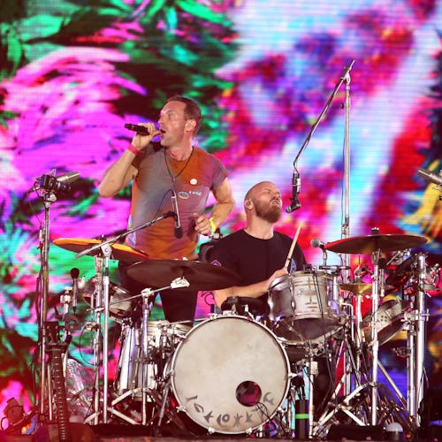 Chris Martin and Will Champion of Coldplay perform at Wembley Stadium on August 12, 2022 in London, ...