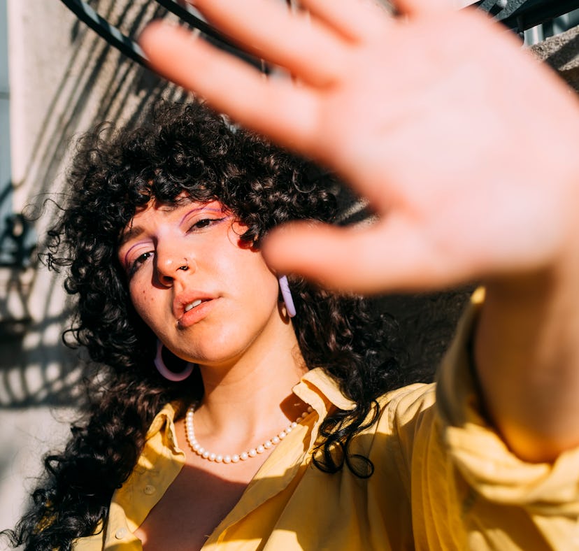 a young woman reaches her hand toward the camera as she reflects on the spiritual meaning of the aug...