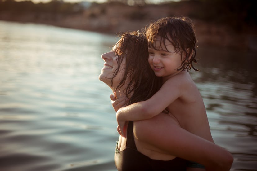 mother and toddler boy wade in the ocean in an article about baby boy names that start with W