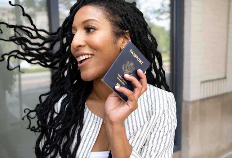 A woman with her passport, because one of the fall 2022 travel trends is long-haul flights. 