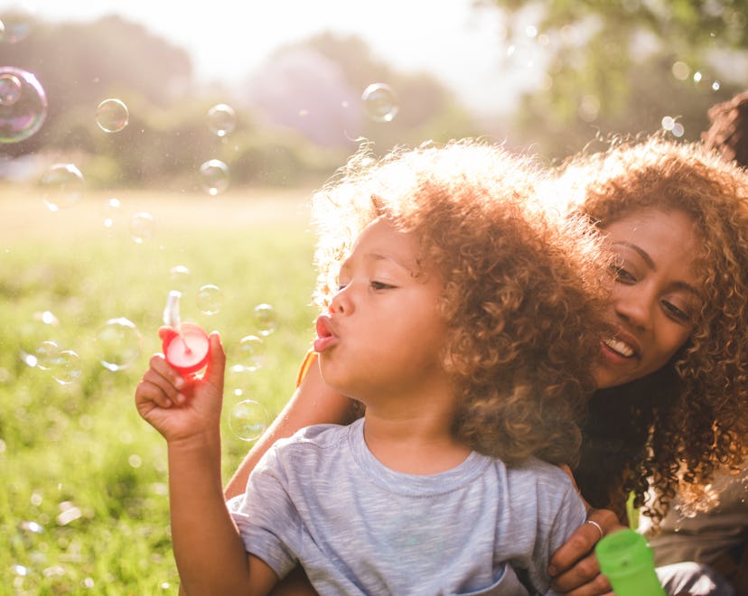 Soft glowing sunny moment between a young african-american mother and her cute curly haired baby boy...