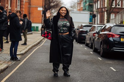 Model Paloma Elsesser waves and wears a black leather trench, black Martin Luther King Jr. shirt, bl...