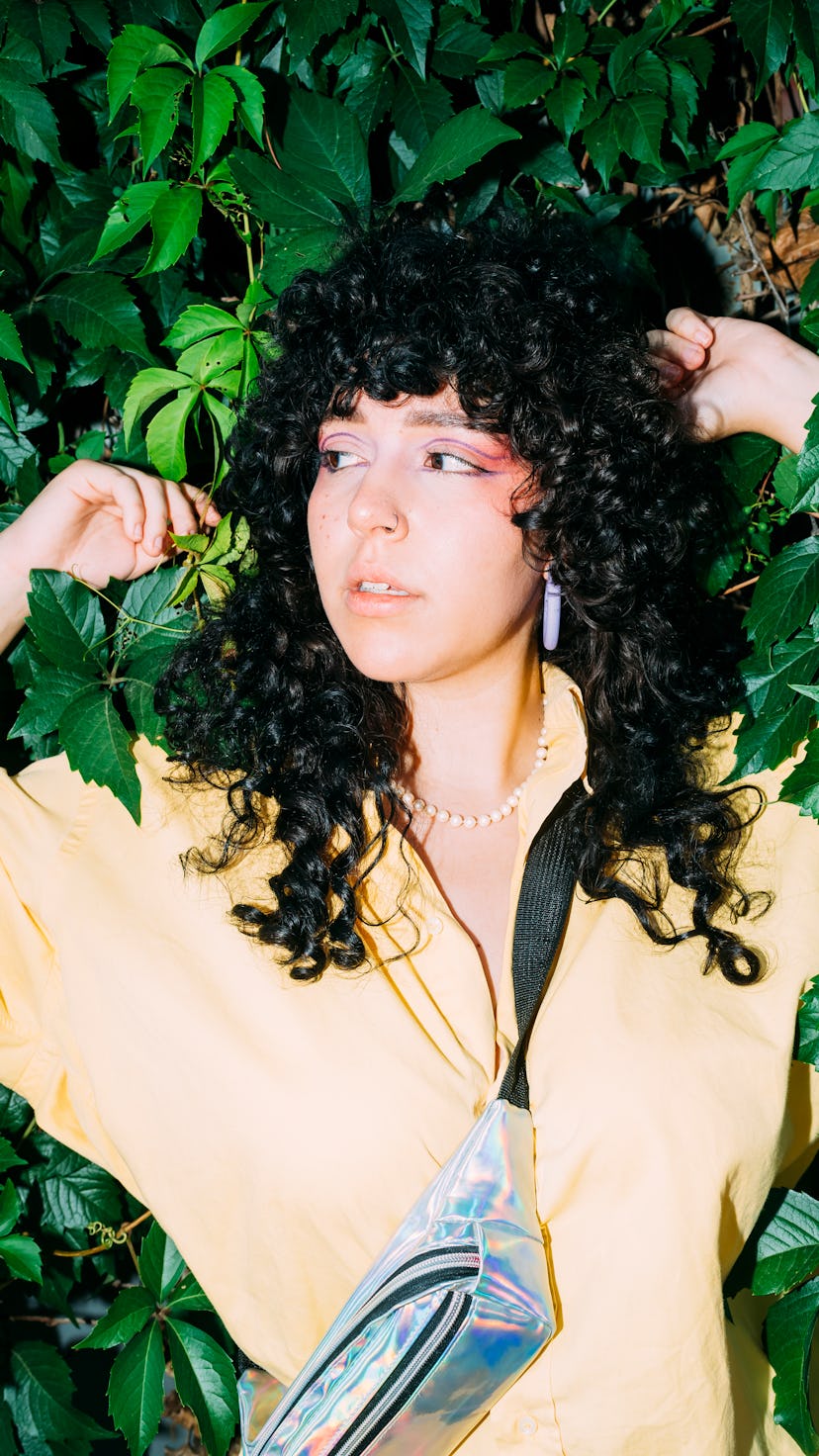 A woman poses in front of a bush. Virgo season begins August 22.