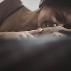Young passionate couple kissing with their eyes closed in a bed.