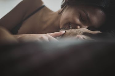 Young passionate couple kissing with their eyes closed in a bed.