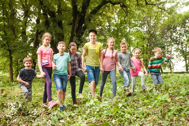 A group of kids of various ages walk through the woods. Russia is offering mothers a medal and $16,0...