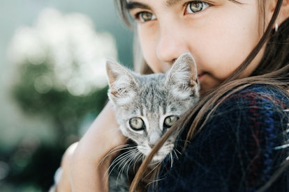 Portrait of child with kitten in an article about instagram captions for international cat day