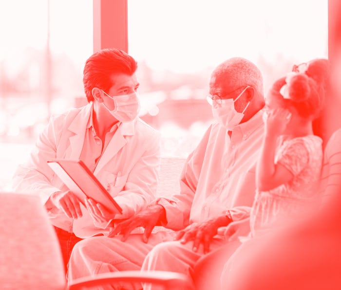 The mid adult male doctor uses his digital tablet to show the senior adult man the medical record. ...