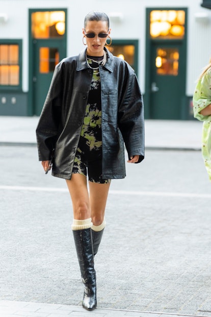 Bella Hadid wearing an embossed leather jacket and leather knee-high boots 