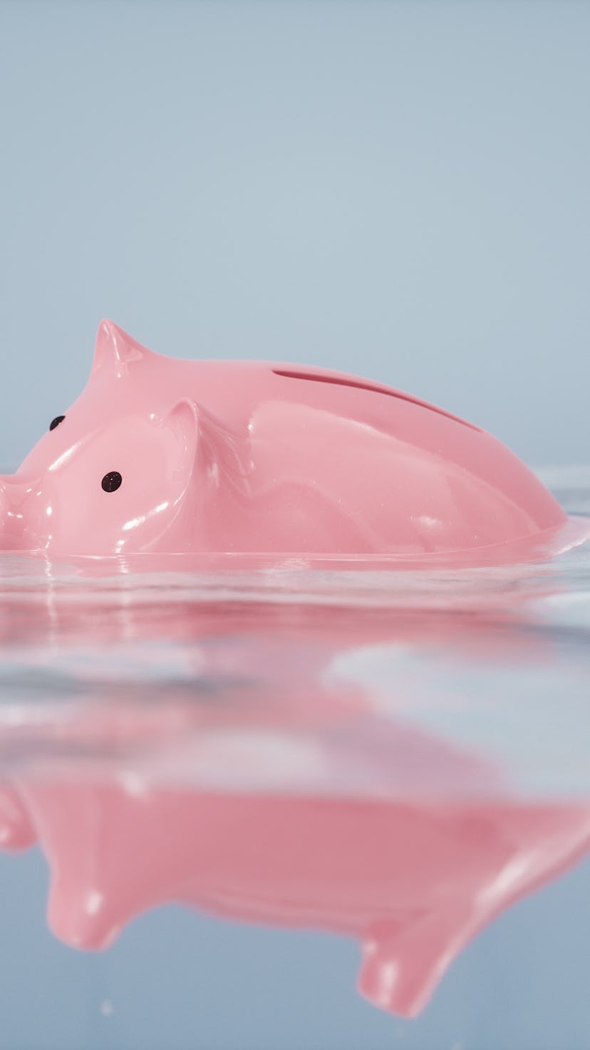 Sinking piggy bank in the water.