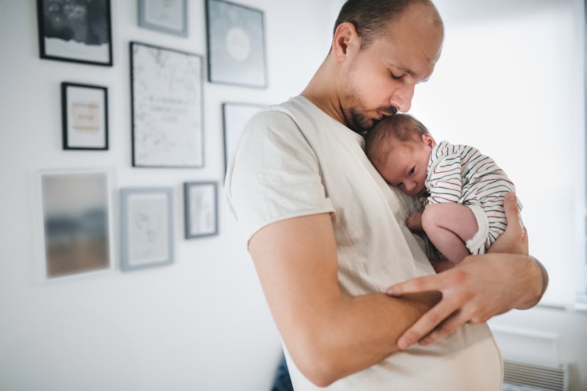dad holding newborn baby in an article about baby congestion no muscus in nose and what to do. 