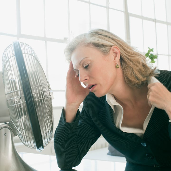 Woman experiencing a menopausal hot flash. New research links a later onset of menopause to overall ...