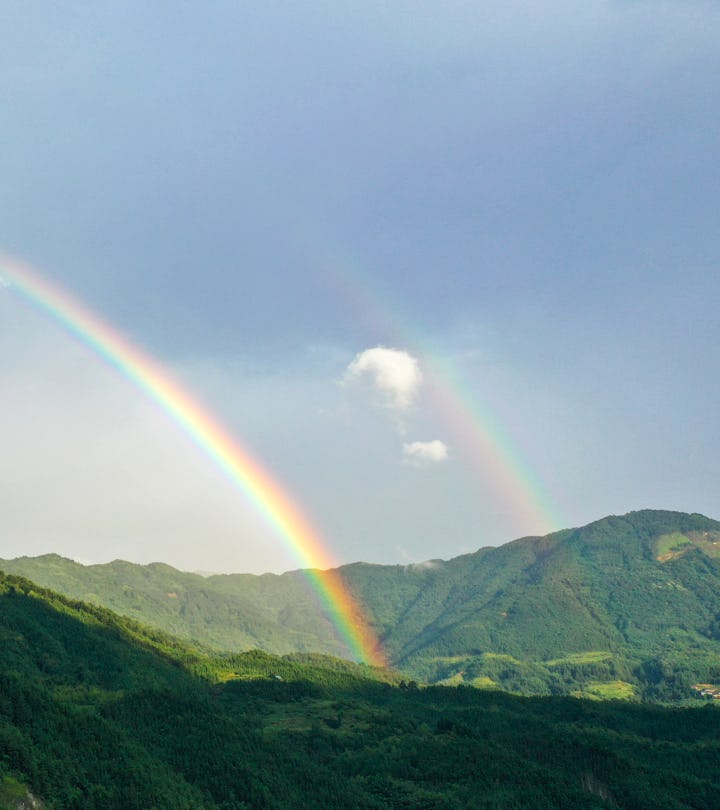 a double rainbow against a blue sky in an article about the term double rainbow baby and what it mea...