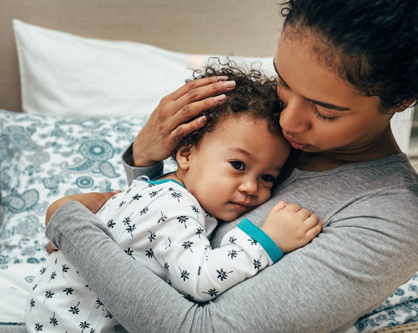 mom snuggling her baby in an article about what to do when your baby sounds congested by has no mucu...