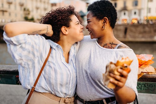 Female friends sharing a loving moment in a city