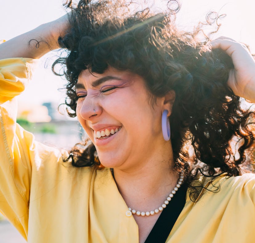 young woman smiles as she thinks about her august 29, 2022 weekly horoscope