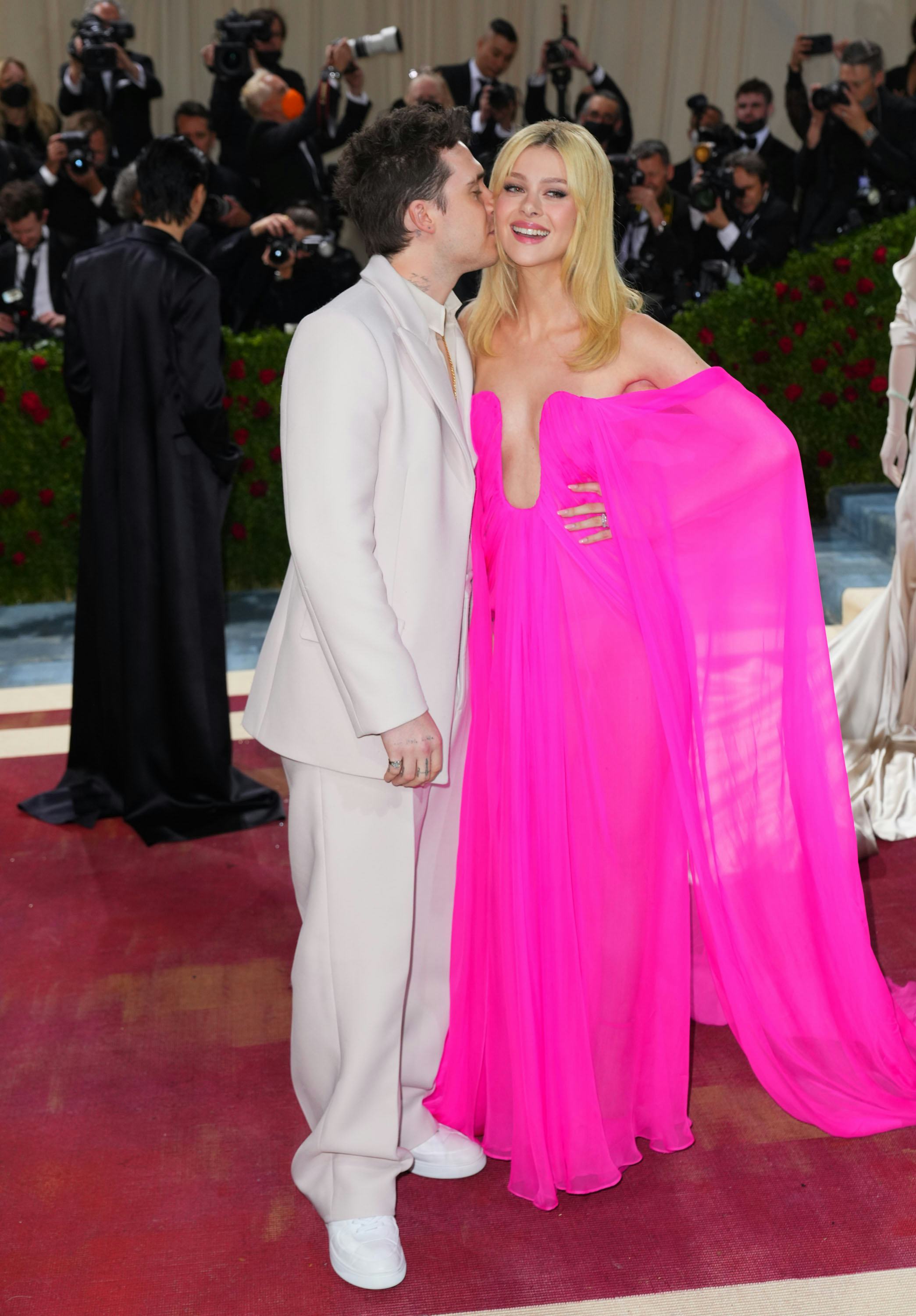 Nicola Peltz's post-wedding style includes bright colors as seen in this pink draped gown, at the 20...