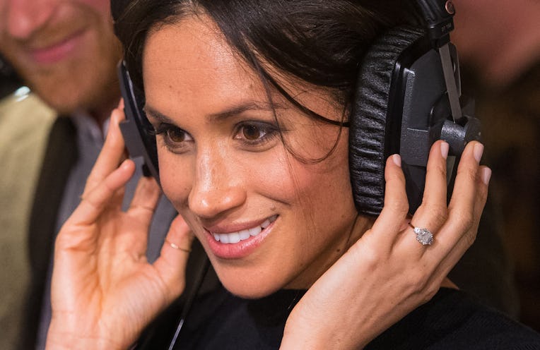 Britain's Prince Harry's fiancée US actress Meghan Markle listens to a broadcast through headphones ...