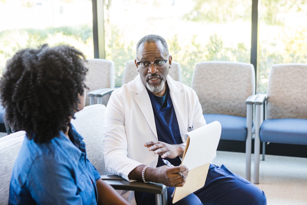 The surgeon talks with the female patient about the serious side effects of her upcoming procedure.