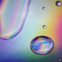 Drops of clear fluid on holographic paper