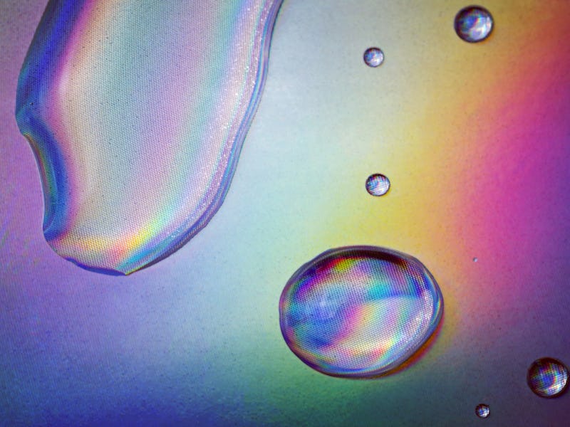 Drops of clear fluid on holographic paper