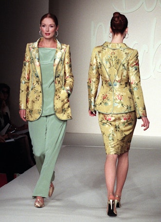 NEW YORK, UNITED STATES:  A model (L) wears a yellow flowered brocade jacket with celadon satin trim...