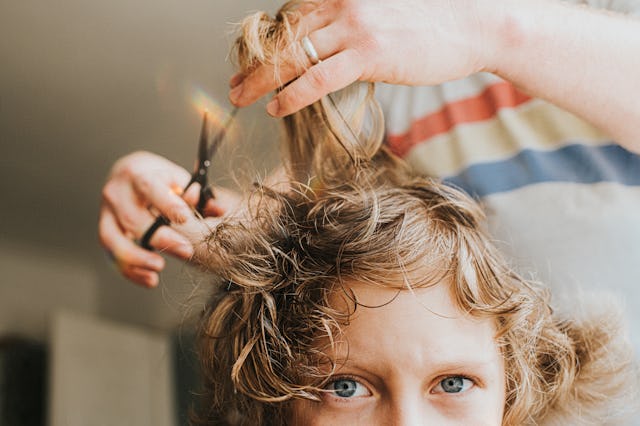 Comical image of young boy having a lockdown haircut at home, during the Covid Pandemic. Boy looks d...