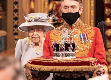 Britain's Queen Elizabeth II walks behind the Imperial State Crown as they process through the Royal...