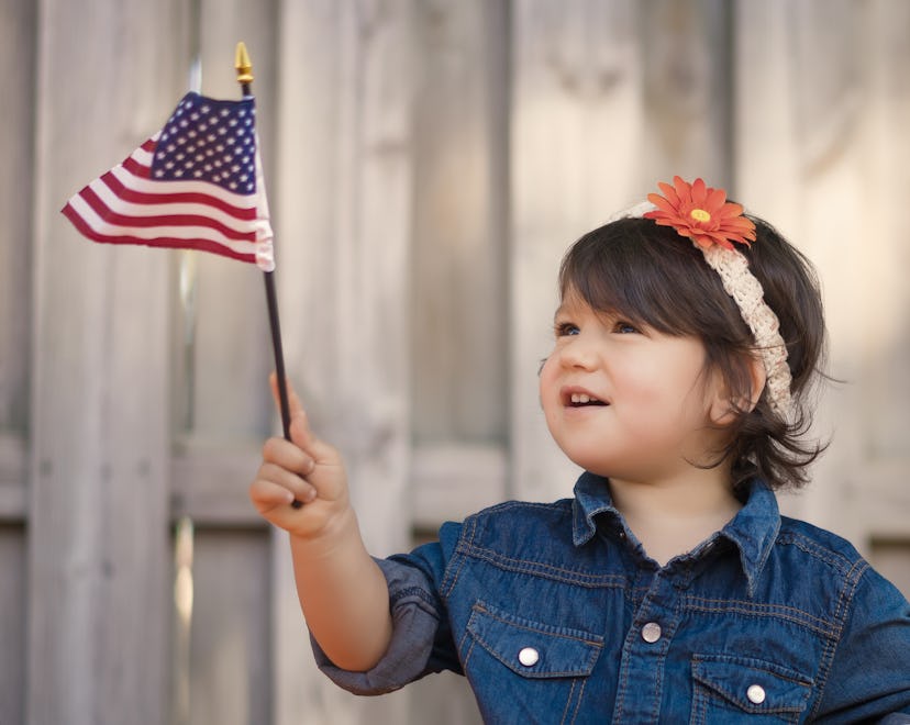 Little girl waving an small American flag in a story about Carter's Labor Day sale.