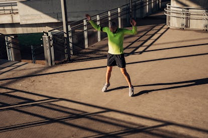 A man doing jumping jacks outside.