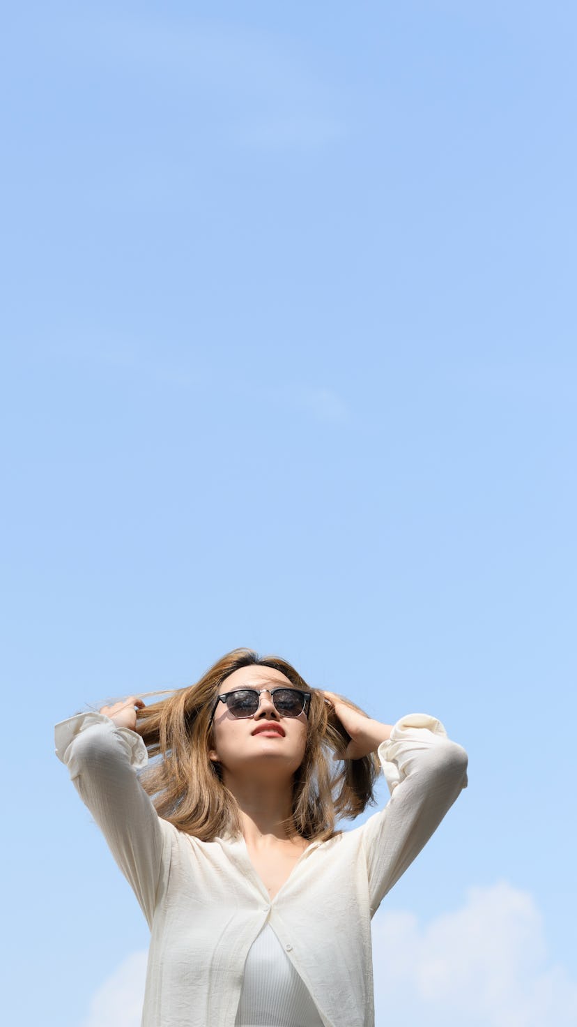 Portrait Of Young Woman Wearing Sunglasses At Beach Against Clear Sky. Uranus retrograde is about ch...