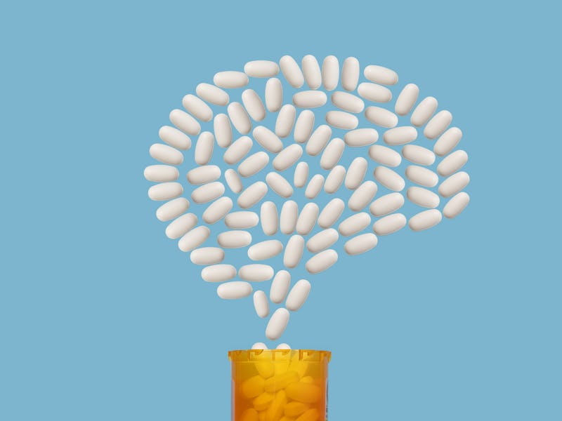 White pills emerging from prescription pill bottle forming shape of human brain, blue background