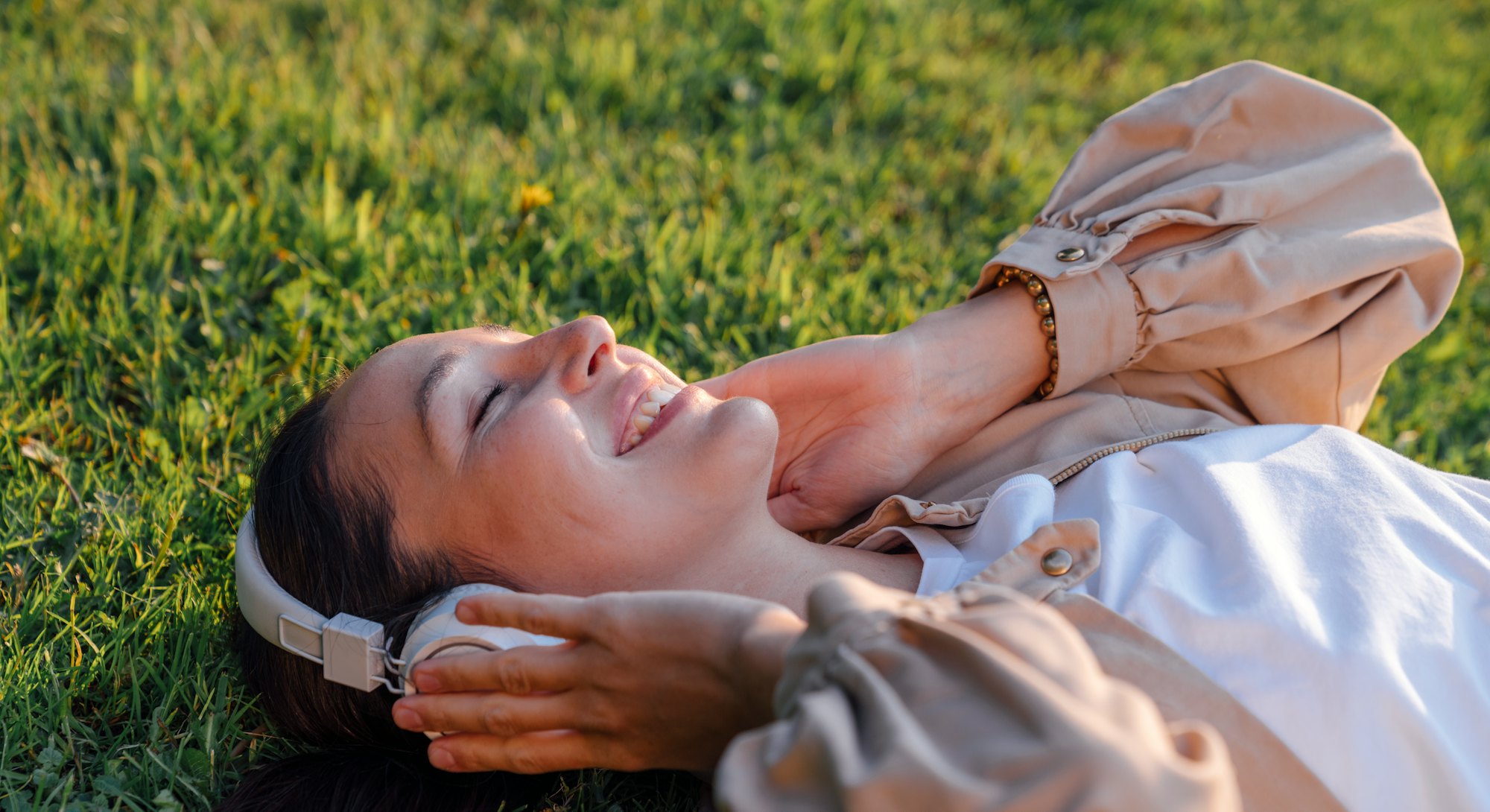Close-up of woman lying in the grass smiling. Despite rocky astrology in September, there are select...