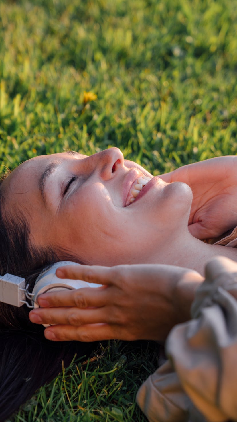 Close-up of woman lying in the grass smiling. Despite rocky astrology in September, there are select...