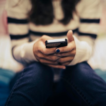 Teen on her phone looking at social media. Instagram just unrolled a new feature that limits how muc...